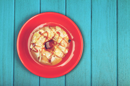 Delicious glazed doughnuts on wooden tableの写真素材