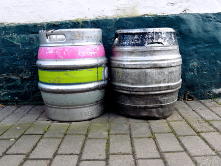 Two beer kegs sitting outside a pub