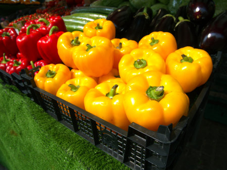 Yellow peppers on sale on a market stallの写真素材