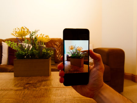 Man shooting a photo of a bed of flowers on phone.の写真素材
