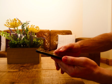 Man shooting a photo of a bed of flowers on phone.の写真素材