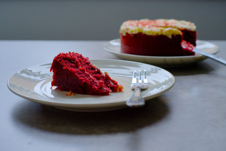 Slice of Red Velvet Cake with a fork on a white plate.