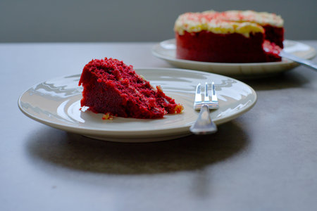 Slice of Red Velvet Cake with a fork on a white plate.の写真素材