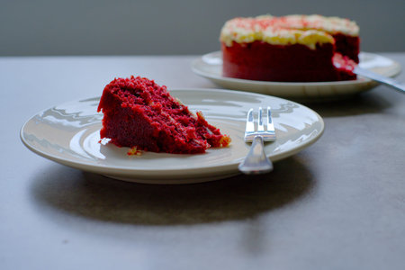 Slice of Red Velvet Cake with a fork on a white plate.
