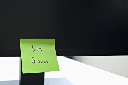 Set Goals sticky note left on a monitor. The bright note stands out against the monitor, symbolising...
