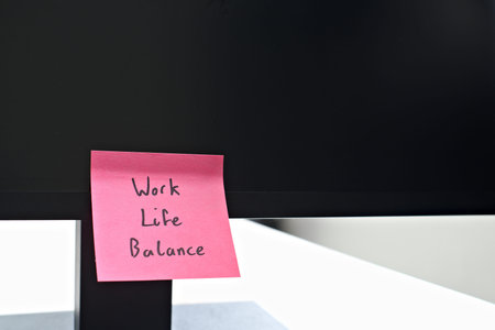 Work Life Balance sticky note left on a monitor. The bright note stands out against the monitor,...