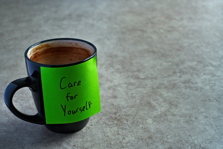 Care for Yourself sticky note left on a mug. The bright note stands out against the mug, symbolising motivation, productivity, and a focused mindset.