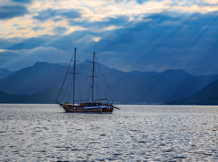 Vintage ship sailing with sun rays.の写真素材