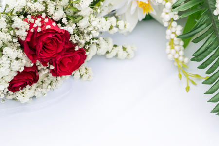 White flowers with red roses decors on white tableの写真素材