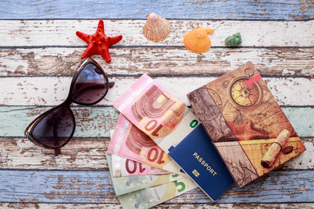 Travel concept: seashells, sunglasses, passport, money and journal on vintage tableの写真素材