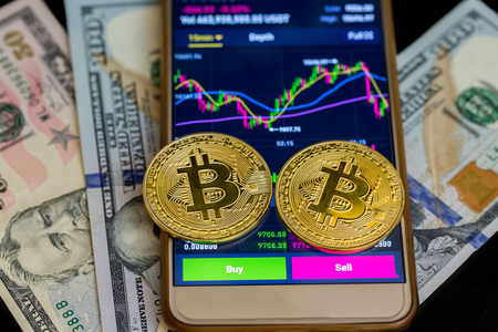 Buy and sell on applications of smartphone with two golden bitcoin on us dollarsの写真素材