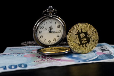 Standing golden bitcoin and pocket watch on turkish liraの写真素材