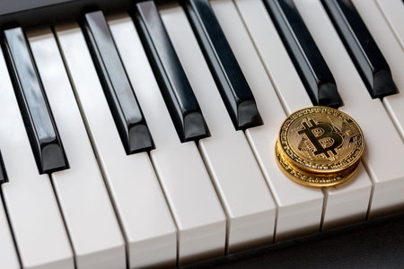 Two golden bitcoins on the keyboards of the piano