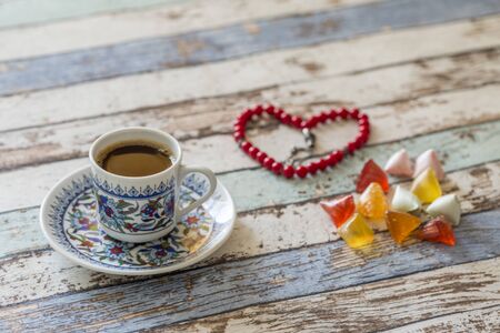 Turkish coffee, sugar candies, and heart shaped rosary on the tableの写真素材
