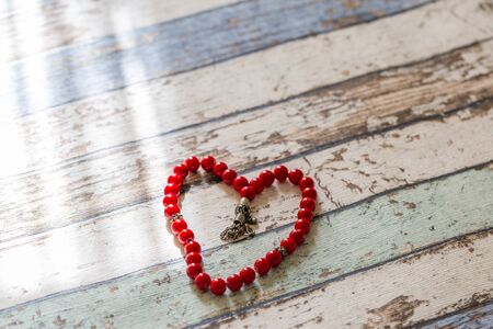 Heart shaped rosary on wooden tableの写真素材