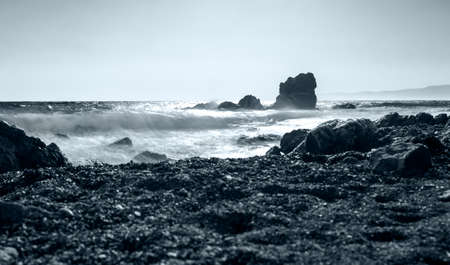 Photographing the waves that hit the rocks in a stormy weather with a long exposureの写真素材