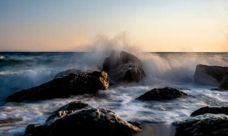 Photographing the waves that hit the rocks in a stormy weather with a long exposureの写真素材