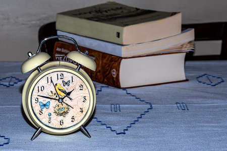 alarm clock and books in the background