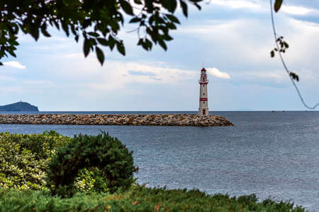 Tree bench and lighthouse by the sea.Turgutreis, Bodrum, Turkeyの写真素材