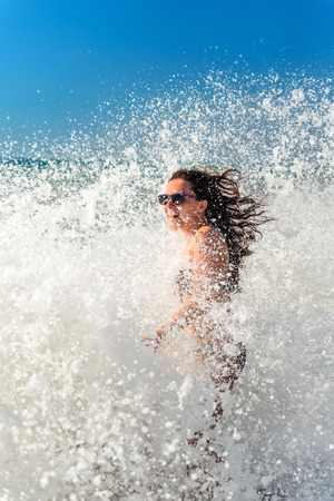 Girl bathes in a storm at sea, a wave washed overの写真素材