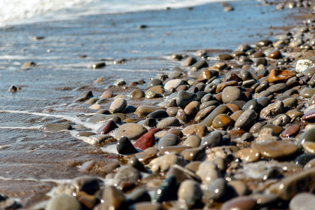 Beach, sea pebbles washed by waveの写真素材
