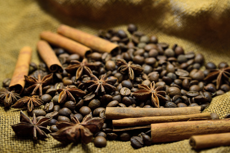 Coffee beans, cinnamon sticks, star anise on the background of old sackingの写真素材