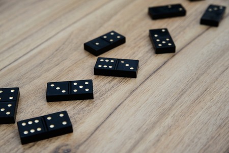 Domino pieces on the brown wooden table backgroundの写真素材