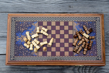 Vintage wooden chess on a wooden chess board. Black and white pieces on the board.