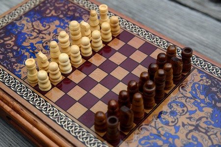 Vintage wooden chess on a wooden chess board. Black and white pieces on the board.の写真素材