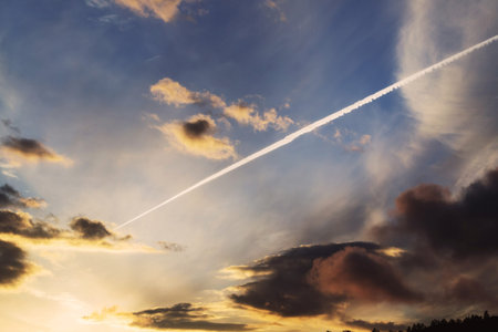 Sunset dramatic sky cuts a strip from an airplane