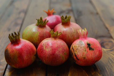 group of pomegranate fruits on a wooden background in the shape of a triangleの写真素材