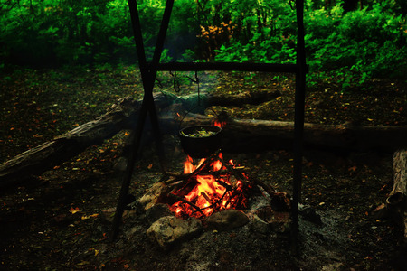 Tea is brewed in a pot on a campfire in a tourist parking lot.の写真素材
