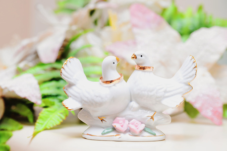 Wedding rings on porcelain doves on the table in the registry officeの写真素材
