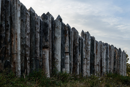 Wooden fence of thick logs with sharp peaksの写真素材