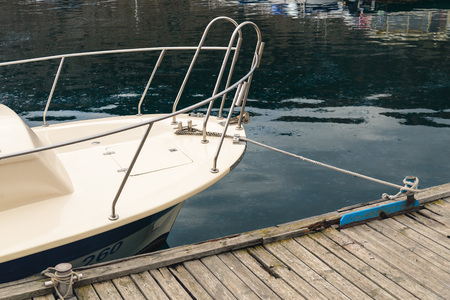 Boat tied with a rope by a sea knot to the pierの写真素材