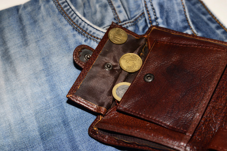 An open wallet with two euro cents is on jeans, the concept of povertyの写真素材