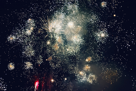 Explosion of diverse fireworks against the night sky on a holidayの写真素材