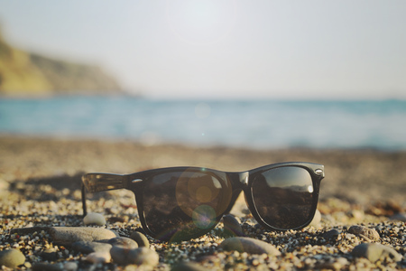 Sunglasses on a sandy sea beach on a sunny summer dayの写真素材