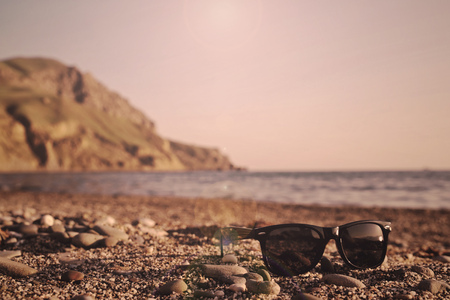 Sunglasses on a sandy sea beach on a sunny summer dayの写真素材