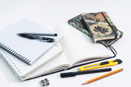Notebooks, exercise books and office supplies lie on a white background, school and office supplies, creative conceptの写真素材