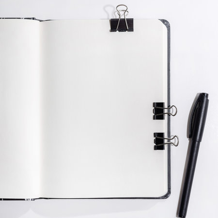 Opened unlocked notebook on a white background with clips, mockup