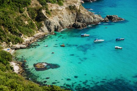 Several yachts stand in a bay in the azure blue sea in the tropicsの写真素材