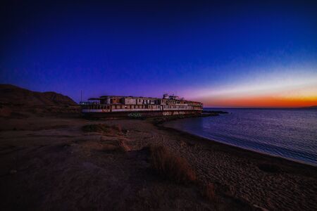Abandoned old ship on the seashore at sunsetの写真素材