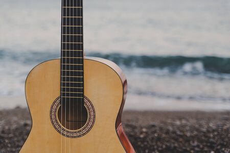 Classic six-string guitar on the beach by the seaの写真素材