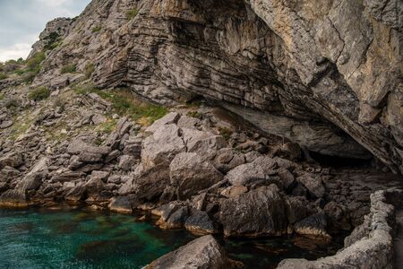 Rocky seashore, quiet sea bay, large grotto with a pathの写真素材