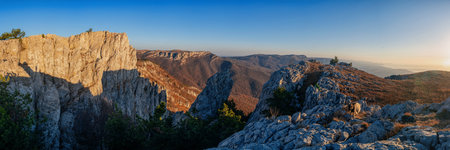 Gorgeous wide panorama of a rocky mountain range in autumn at sunrise