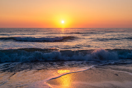 Beautiful sunny dawn in the clear sky on the sea coast during a storm