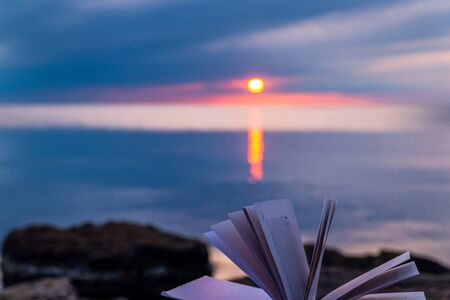 Book by the sea against the blue sunset sky, reading in silence, nobodyの写真素材