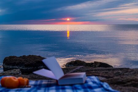 Book by the sea against the blue sunset sky, reading in silence, nobodyの写真素材