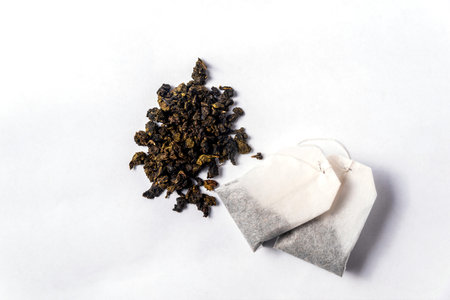 Green tea bags and loose green tea on a white backgroundの写真素材